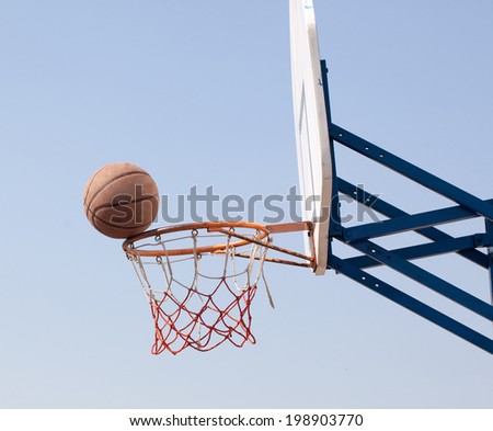 Ring and ball on background of the sky and the city.Basketball in Flight