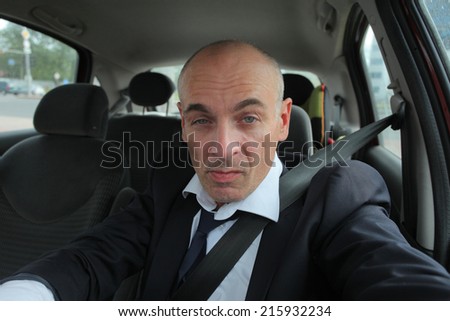 adult businessman behind the wheel of car