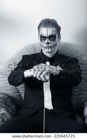 portrait of a man in make-up Halloween. drawing a vampire on his face.
