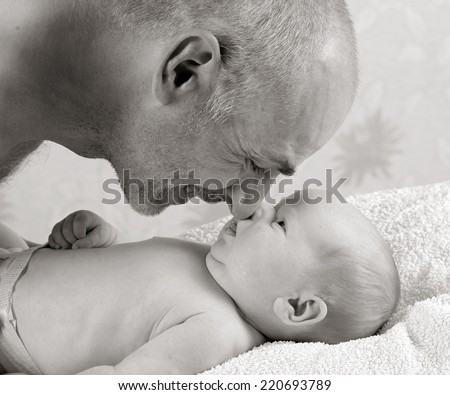 father and son. Dad plays with an infant