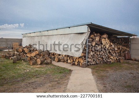 Thick wood under cover. Supply of fuel for the winter
