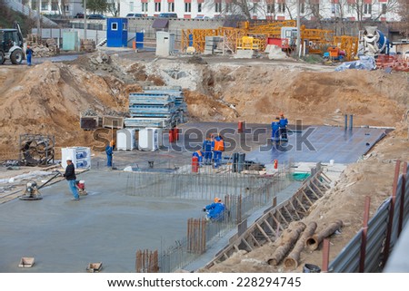 Renaissance construction workers reinforce fitting. The concrete foundation of the hotel building.Polishing concrete special tools.  Belarus,Minsk,November,1,2014