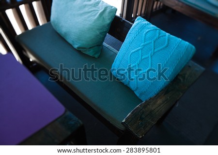 colored knitted blue pillow on the sofa in the cafe