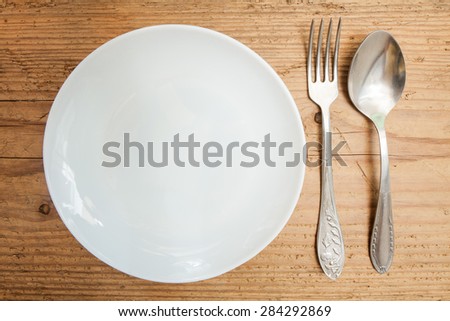 clean plate serving spoon and fork on a old  wooden table