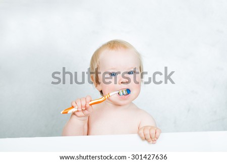 baby toddler learning to brush their teeth with a brush