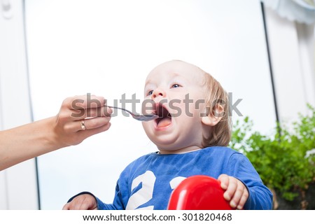 feeding baby with a spoon open mouth