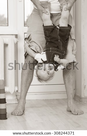 baby upside down holding Dad