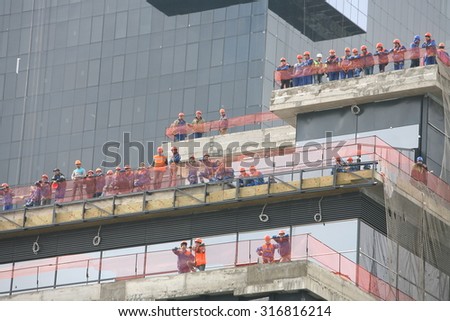 Builders working on a high-rise building, looking down. Construction company workers Turkish Renaissance Group. Belarus, Minsk, 13 September 2015