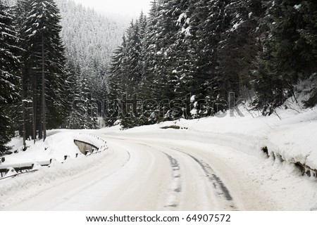 road curve in winter with lot of snow and snow barriers