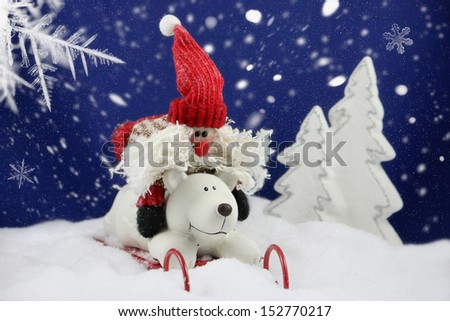 funny santa claus and polar bear on sleigh ride in a snow-covered landscape