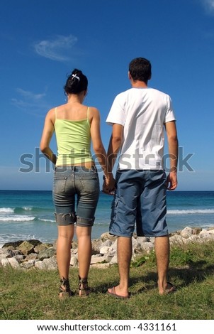Planning the Future - young couple holding hands on beach background