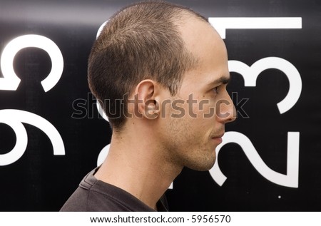 Man and numbers - Profile of a young man against black and white numbered background