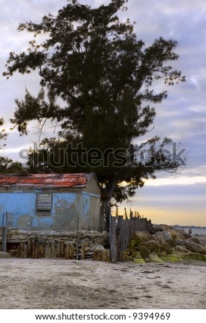 Beach scene with rustic cabin at sunset