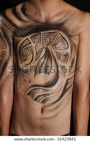 Detail of young male torso with artistic bodypaint drawing
