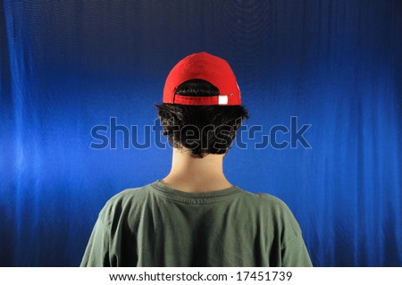 Portrait of young casual man wearing a cap - view from the back