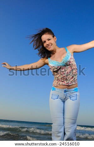 Portrait of young fashion woman enjoying the summer breeze by the ocean