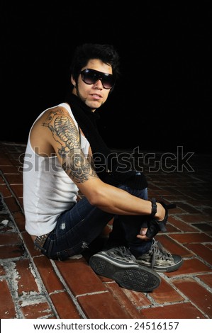 Portrait of young cool male model sitting on a roof