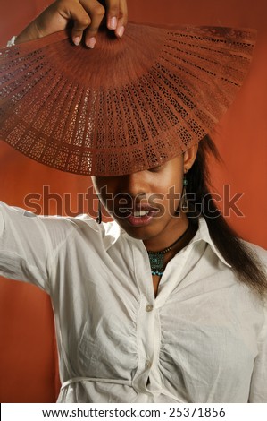 Portrait of young african female model holding fan