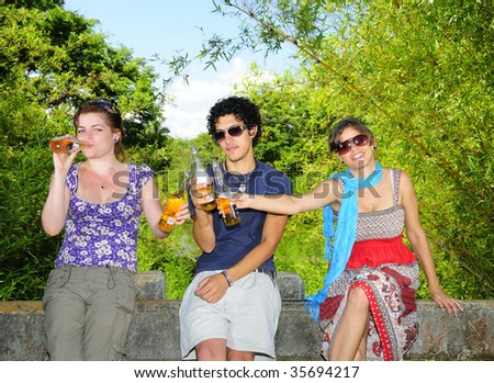 Portrait of three young friends drinking beer in natural environment