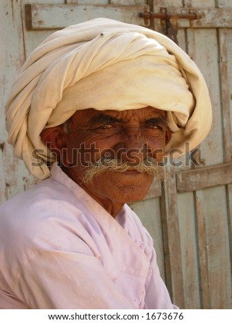 an old tribal man posing in a village in india