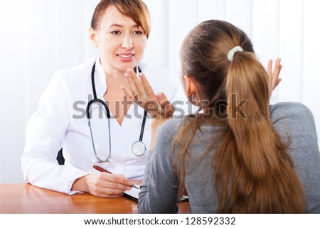 Happy Doctor with Stethoscope Giving Consultation to Patient in Clinic. Doctor with female patient