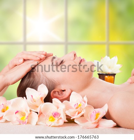 Beautiful Young Woman Getting Massage Facial and Body in Spa Salon. Treatment Cosmetics Beauty Care Body Herbs Surrounded by Flowers