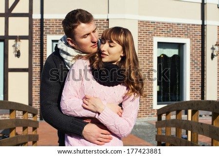 Portrait of Beautiful Young Couple in Love romantic trip to Europe. Man and Woman Smiling Charmingly. Young Couple Kissing Summer on Sunny Sky Background