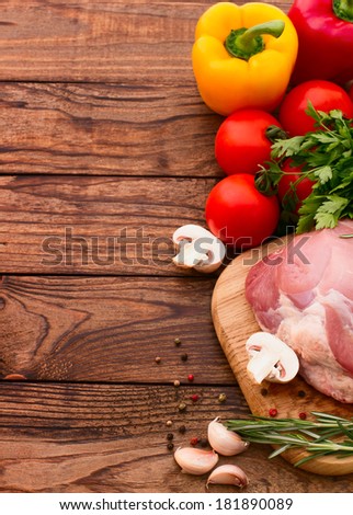 Sliced pieces of raw Meat for barbecue on wooden surface, menu cooking recipes. Food, raw steak, beef steak bbq, tomatoes, peppers, spices for cooking meat.