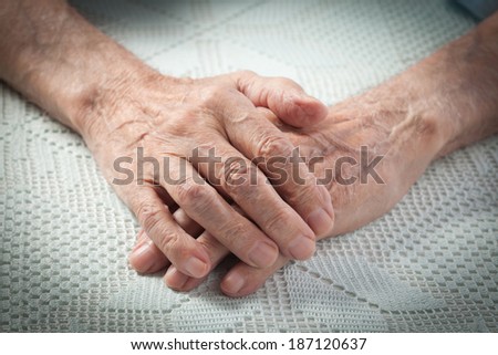 Care is at home of elderly. Old people holding hands. Closeup. Elderly man