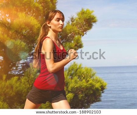Running woman. Runner jogging in sunny bright light. Summer sea. Female fitness model training. Female runner jogging during outdoor workout on beach.