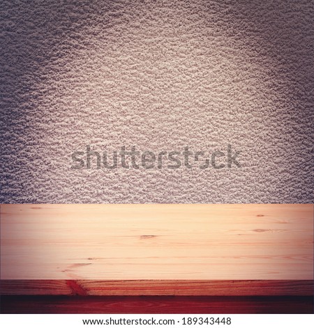 Empty wooden deck table on background texture of gray wall for product montage. Free space for your text