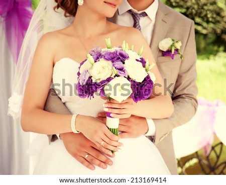 Wedding couple holding hands. Bride and groom holding hands. Wedding bouquet closeup. Fashionable toning. Wedding invitation, Selective focus