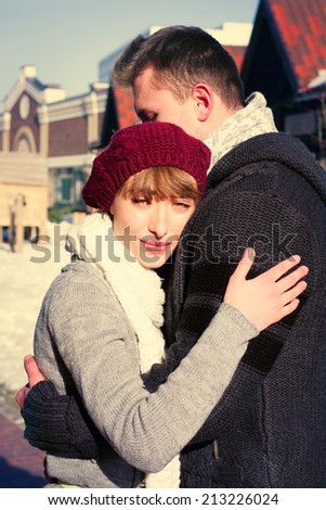 Portrait of young sensual couple in cold winter weather. Love and kiss. Young people. Snow lovers kiss city. Fashion clothing