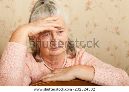 Elderly woman grieves at home. Single people. Woman upset headache