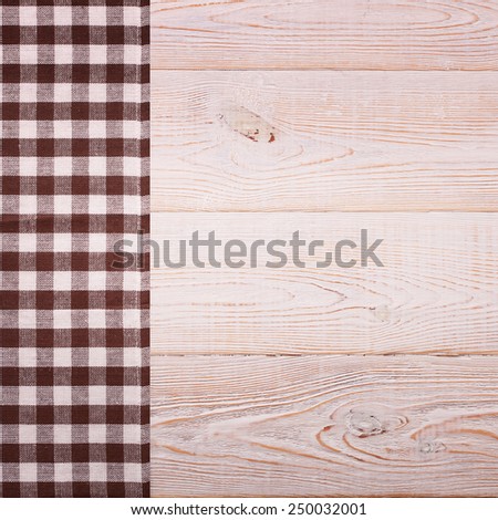 Top view of checkered napkin tablecloth on white wooden table. Unique perspectives