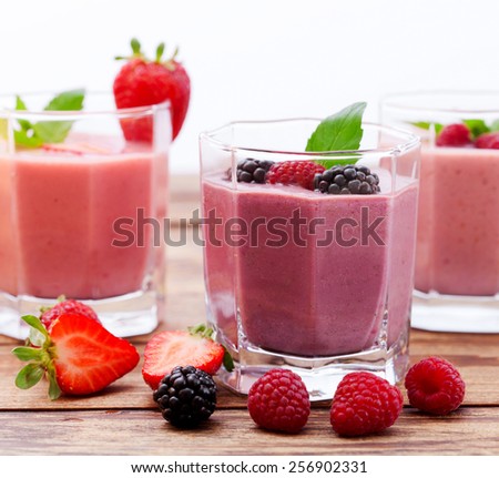 Drink smoothies summer strawberry, blackberry, raspberry on wooden table.