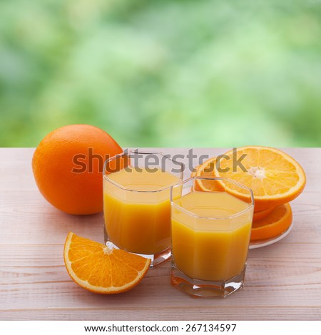 glass of juice with fresh orange on white wooden table
