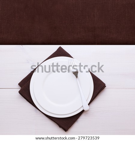 Empty plates and cutlery on table cloth on wooden table for dinner, menu in restaurant Top view square. Flat mock up for design.
