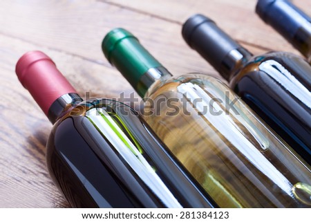 Wine bottles close up on wooden desk. Flat mock up for design.