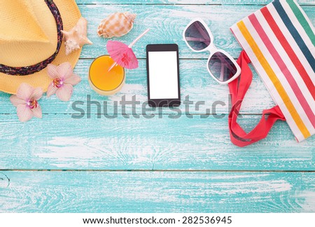 Blank empty tablet computer on the beach. Trendy summer accessories on wooden background pool. Sunglasses, orange juice and flip-flops on beach. Tropical flower orchid. Flat mock up for design.