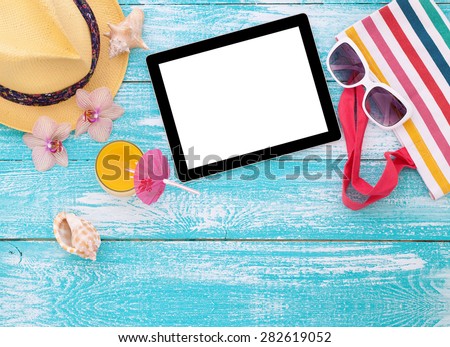 Blank empty tablet computer on beach. Trendy summer accessories on wooden background pool. Sunglasses, orange juice and flip-flops on beach. Tropical flower orchid. Flat mock up for design.
