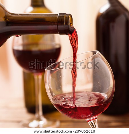Red wine pouring into wine glass, close up. Flat mock up for design.