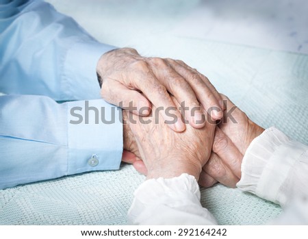 Elderly people holding hands. Closeup.