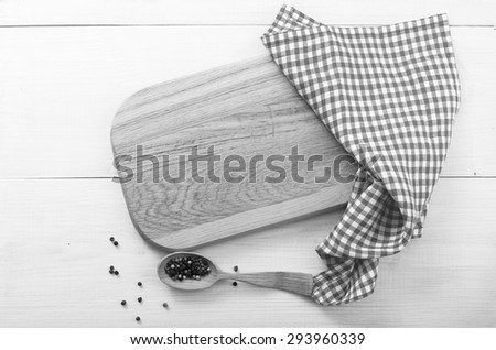 Empty kitchen cutting board with spilling spices. Wooden table covered with tablecloth. View from top.