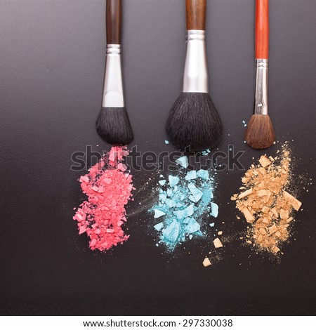 Makeup brush with powder foundation on black background