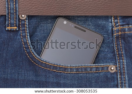 Modern phone in jeans pocket displaying screen.