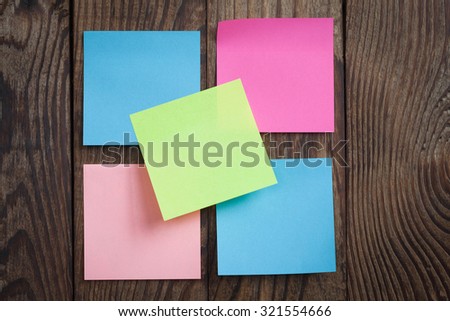 multicolored empty paper sticks for notes hanging on wooden noticeboard