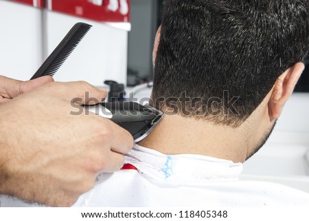 Barber cutting hair with electric razor at a barber shop