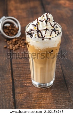 Iced coffee frappe with whipped cream in glass cup on wooden table Photo stock © 