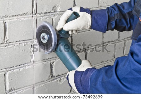A man working with grinder, close up on tool, hands and sparks, real situation picture